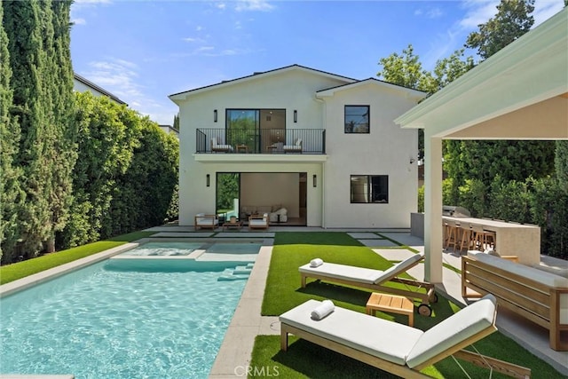 rear view of property with a yard, an outdoor hangout area, a balcony, a bar, and a patio