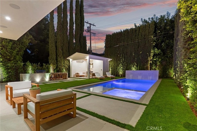 pool at dusk featuring exterior bar, an outdoor living space, and a patio area