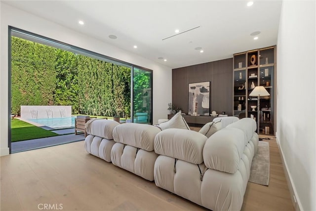 bedroom with access to outside, golf simulator, and light wood-type flooring