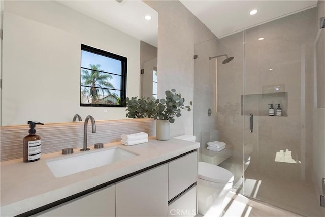 bathroom with an enclosed shower, vanity, toilet, and backsplash