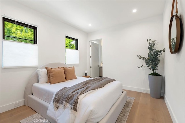 bedroom with light hardwood / wood-style flooring and multiple windows