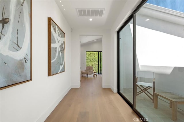 corridor featuring light hardwood / wood-style floors and lofted ceiling