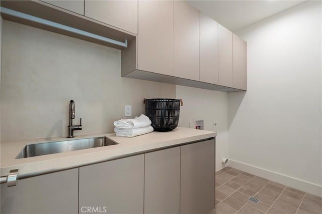 clothes washing area featuring electric dryer hookup, cabinets, sink, hookup for a washing machine, and light tile patterned floors