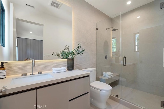 bathroom featuring vanity, an enclosed shower, and toilet