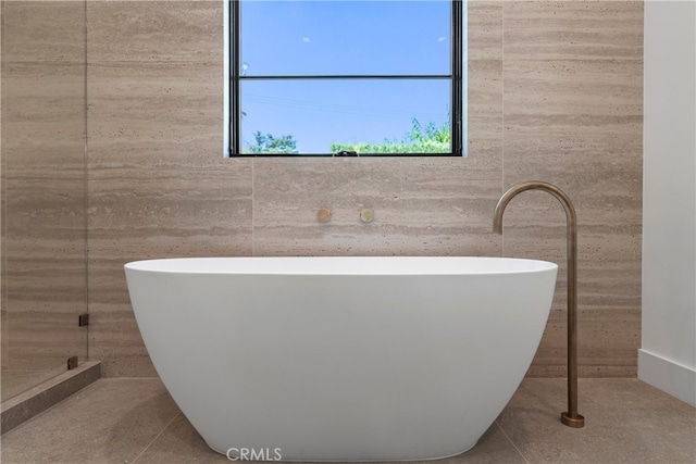 bathroom featuring a bathtub and tile walls