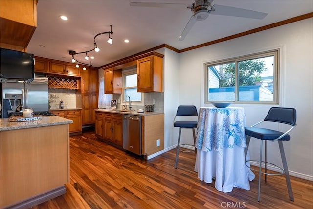 kitchen with sink, decorative backsplash, ornamental molding, stainless steel appliances, and dark wood-type flooring