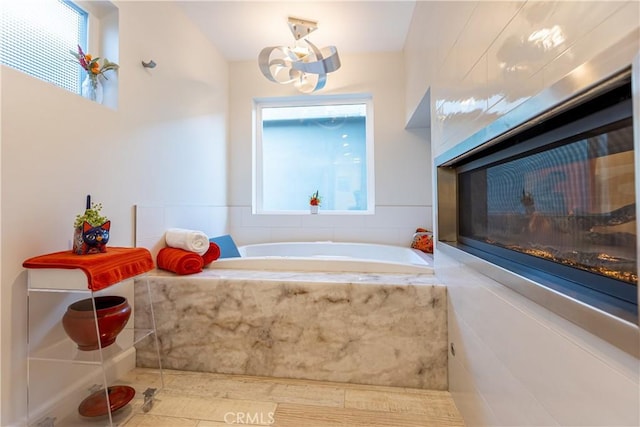 bathroom with a relaxing tiled tub