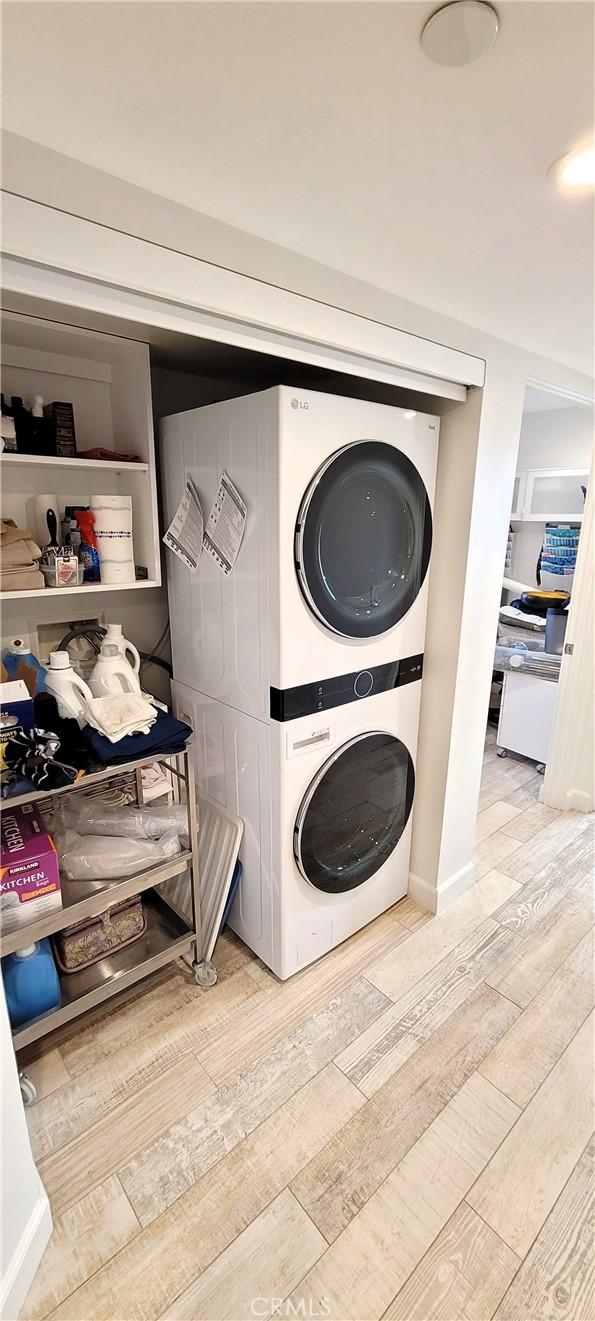 clothes washing area with stacked washer and dryer