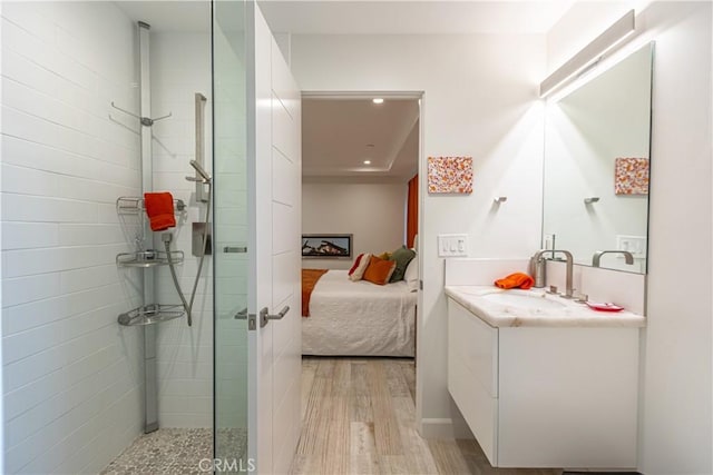 bathroom featuring vanity, tiled shower, and hardwood / wood-style floors