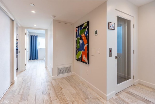 corridor with light hardwood / wood-style flooring