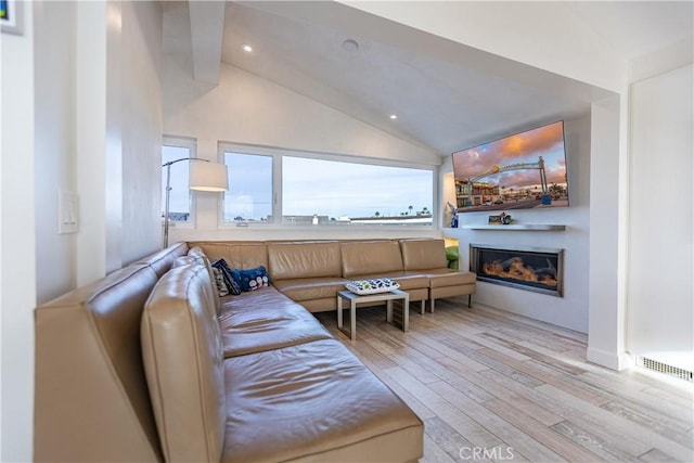 living room featuring light hardwood / wood-style floors and vaulted ceiling