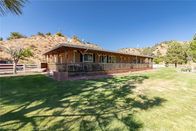 rear view of house featuring a yard, fence, and a mountain view