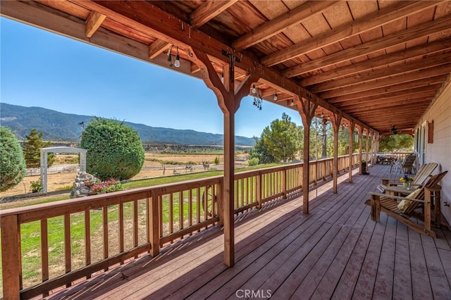 wooden terrace with a lawn and a mountain view