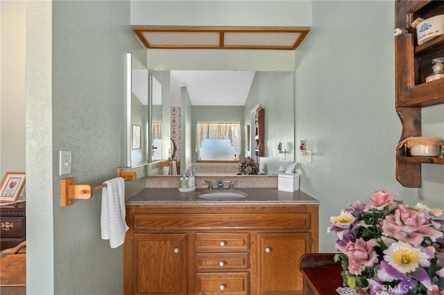 bathroom with a textured wall and vanity