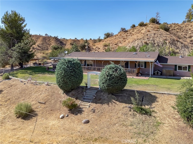 rear view of house featuring covered porch, a yard, stairs, and a mountain view