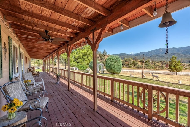 wooden terrace featuring a lawn, ceiling fan, and a mountain view