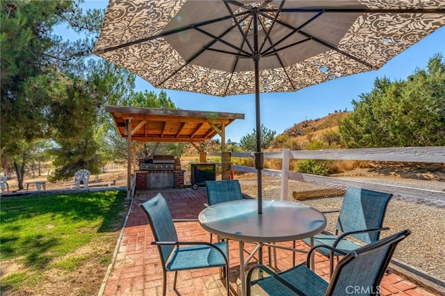 view of patio / terrace featuring an outdoor kitchen, outdoor dining area, and fence