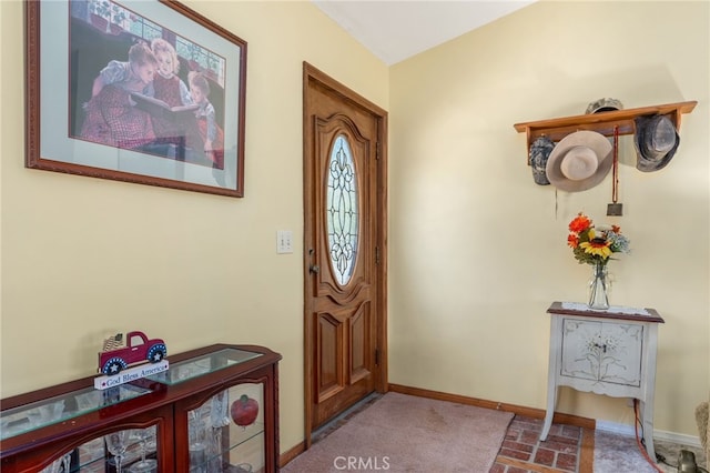 entrance foyer with baseboards and brick floor