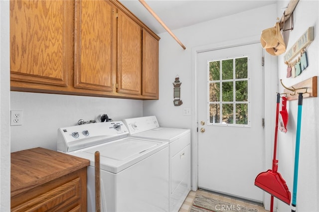 washroom featuring washing machine and dryer and cabinet space