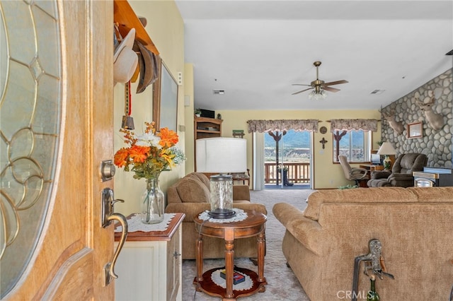 carpeted living room with ceiling fan