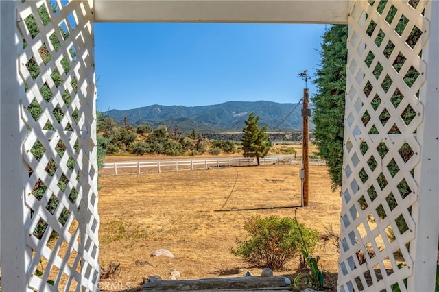 view of yard featuring a mountain view and fence
