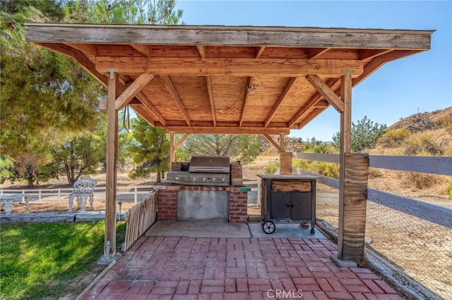 view of patio / terrace with a grill, fence, and exterior kitchen