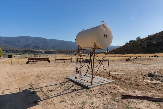 view of yard featuring a mountain view, fence, and a rural view