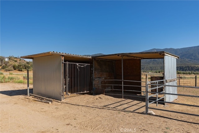 view of stable featuring a rural view and a mountain view