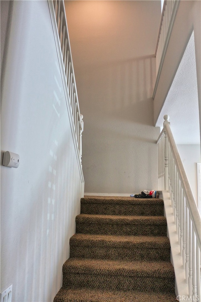 stairway featuring a high ceiling