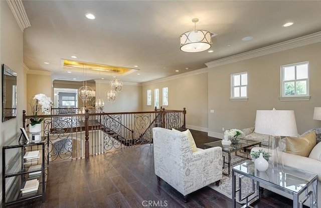 living room with dark hardwood / wood-style floors, crown molding, and a notable chandelier