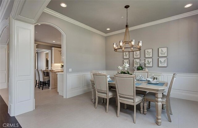 dining area featuring ornamental molding and a notable chandelier