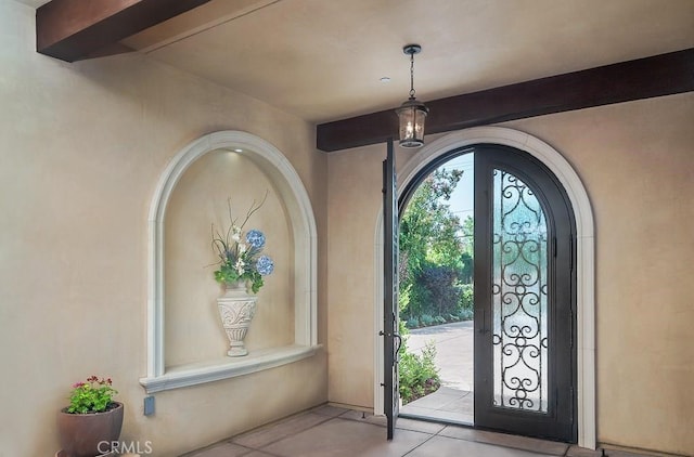 entryway with beam ceiling and light tile patterned floors