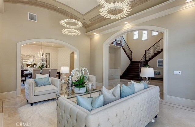 living room with ornamental molding and a notable chandelier