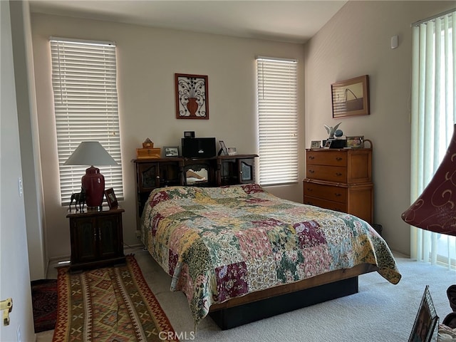 carpeted bedroom featuring multiple windows