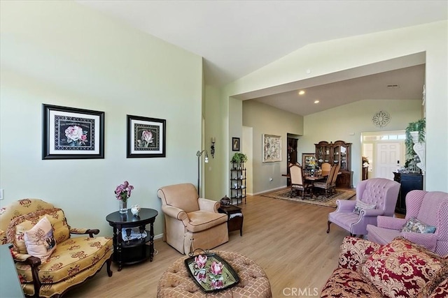 living area with light wood-style floors and vaulted ceiling