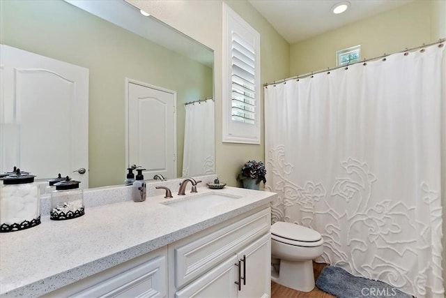 bathroom featuring toilet, wood finished floors, and vanity