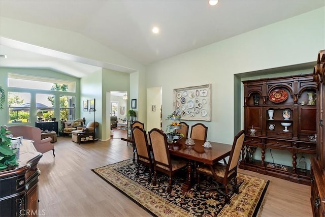 dining room with lofted ceiling, light wood-style flooring, and recessed lighting