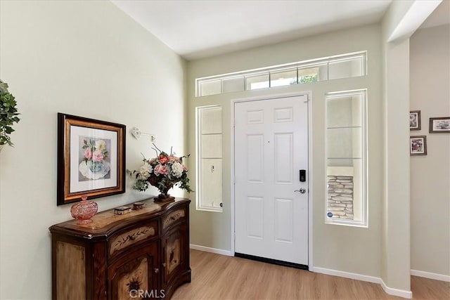 entryway featuring baseboards and light wood finished floors