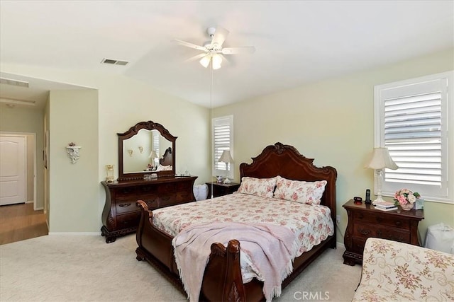 bedroom with visible vents, ceiling fan, light carpet, and baseboards