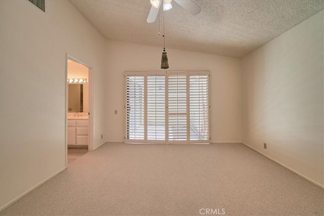 carpeted spare room featuring ceiling fan, a textured ceiling, and vaulted ceiling