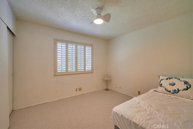 unfurnished bedroom with a textured ceiling, ceiling fan, and carpet floors