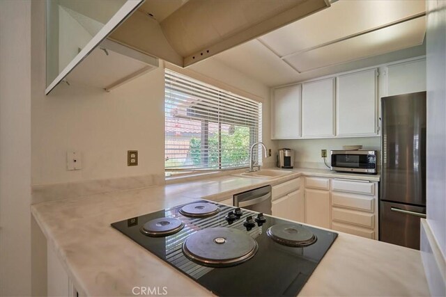 kitchen featuring appliances with stainless steel finishes, sink, and white cabinetry