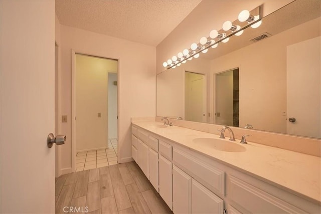 bathroom with vanity and a textured ceiling