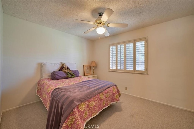 bedroom with ceiling fan, carpet flooring, and a textured ceiling