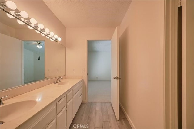 bathroom featuring ceiling fan, a textured ceiling, and vanity