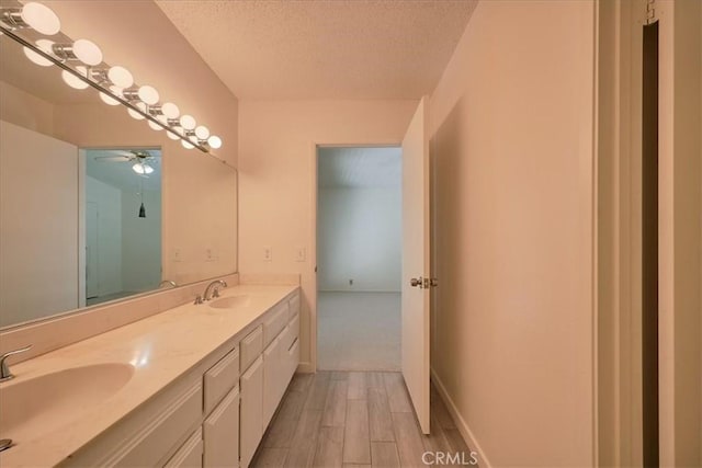 bathroom featuring vanity, wood-type flooring, and a textured ceiling