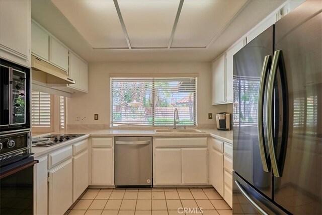 kitchen with light tile patterned floors, sink, white cabinets, and stainless steel appliances