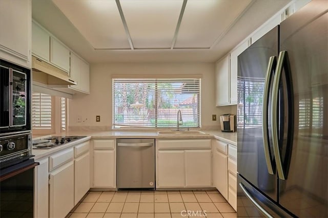 kitchen featuring white cabinetry, sink, light tile patterned floors, and black appliances