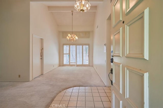 carpeted entrance foyer with beam ceiling, high vaulted ceiling, and an inviting chandelier