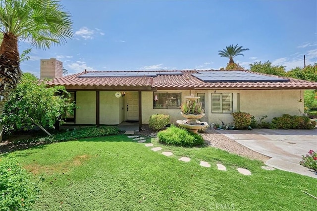 view of front facade with a front yard and solar panels